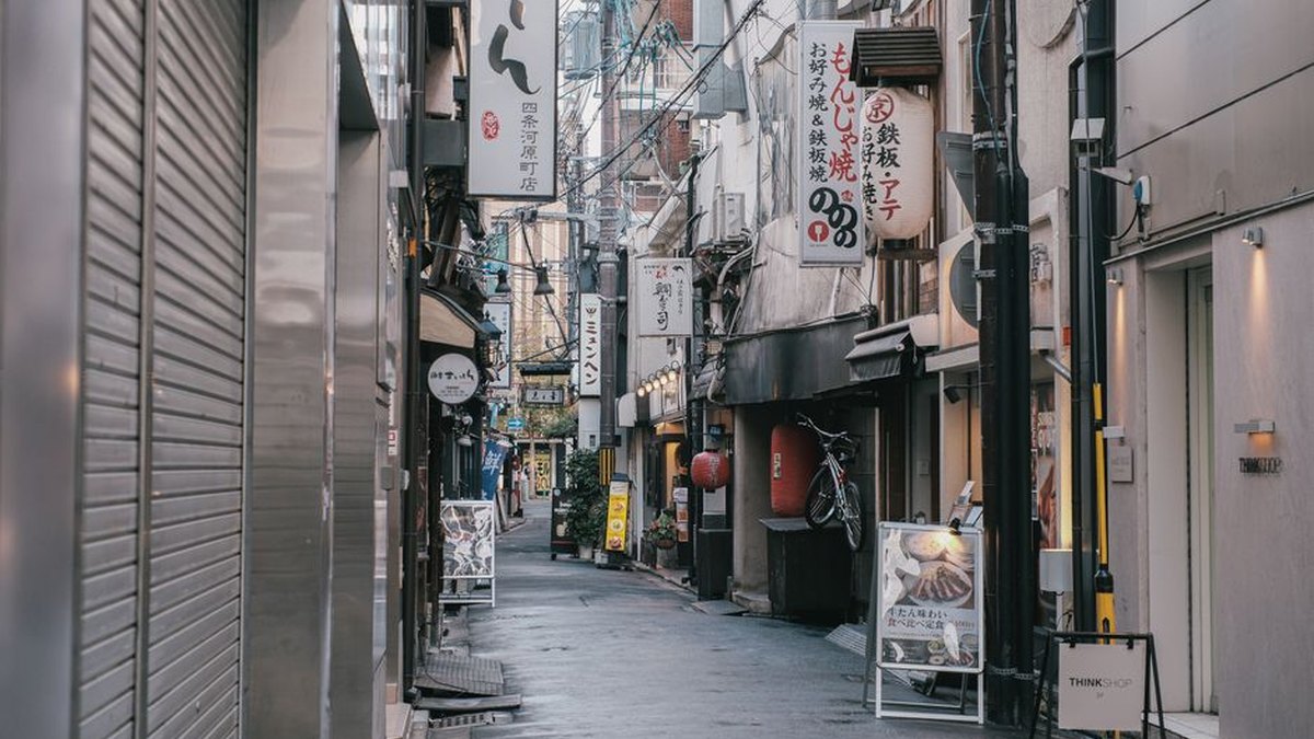 Capture of a quiet, narrow street in Tokyo, showcasing traditional Japanese architecture and vibrant signage.