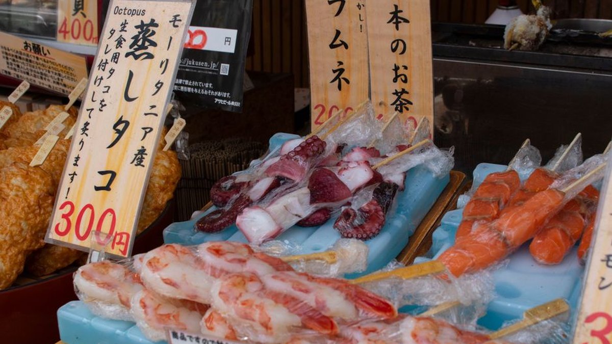 Colorful seafood skewer display at a local Japanese market with visible price tags.