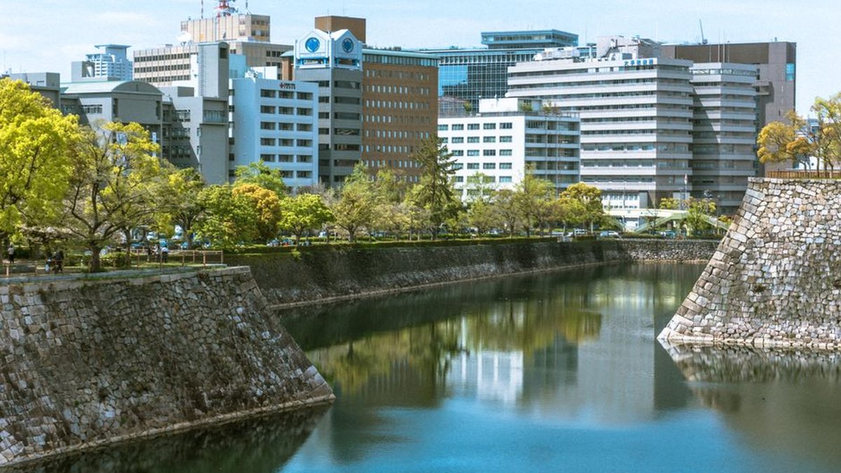 City skyline reflected in a moat surrounded by greenery. Featured in the modern Japanese cityscape.