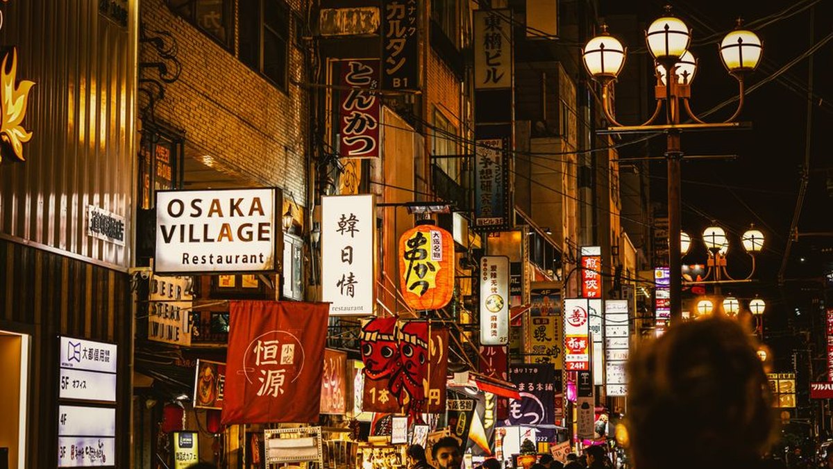 Bustling nightlife in Osaka's Dotonbori, Japan, featuring vibrant signage and a lively street atmosphere.