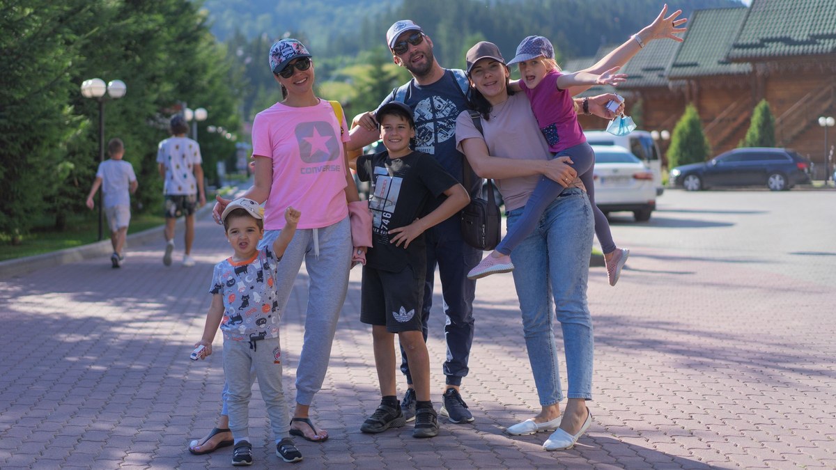 A family of six standing together on a trip