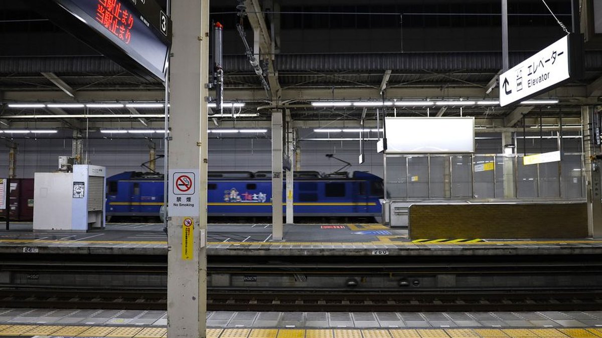 A quiet night scene at Shizuoka Railway Station platform with a moving train.