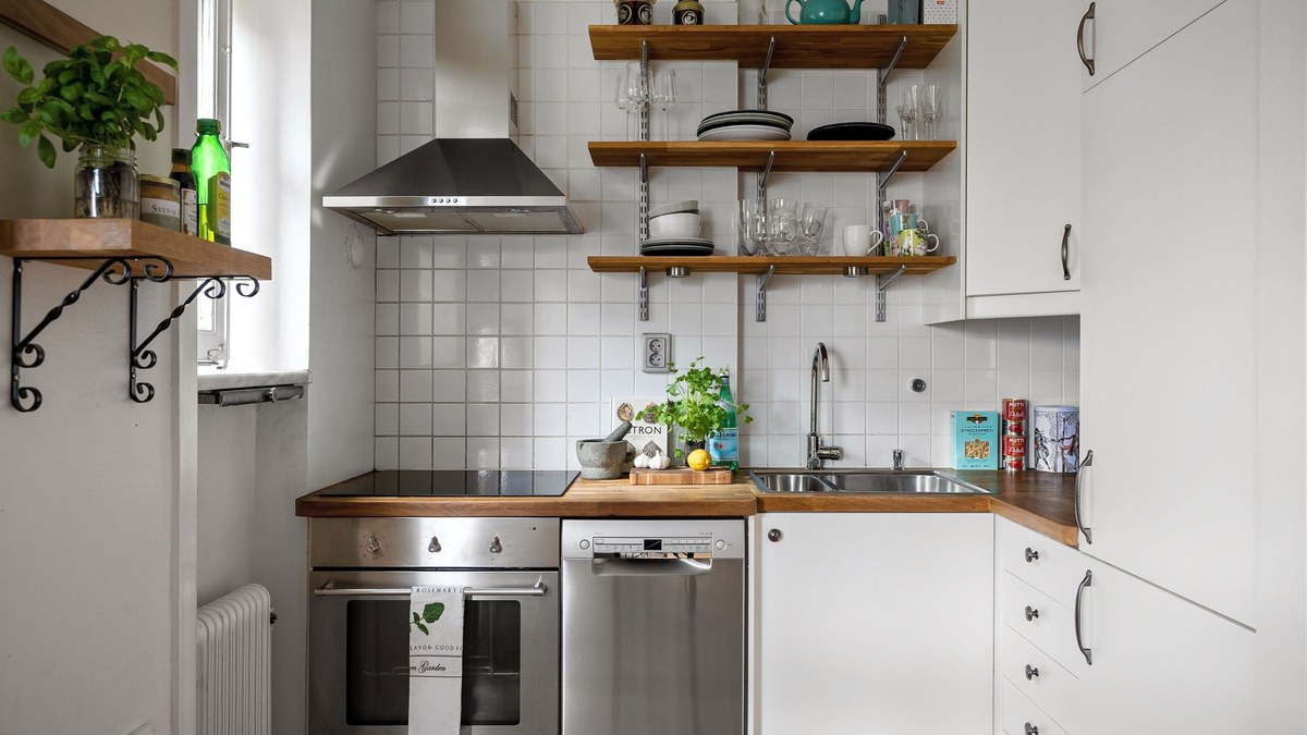 A small kitchen with white cabinets and stainless steel appliances